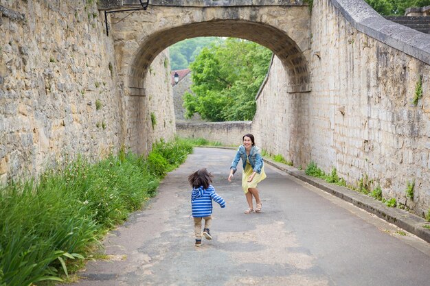 旧市街で野外で遊ぶ母と小さな東部のハンサムな男の子