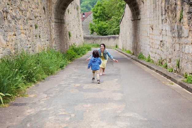 Mother and little eastern handsome baby boy playing outdoor in old town