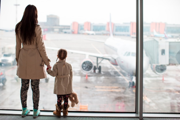 Mother and little girl in airport waiting for boarding