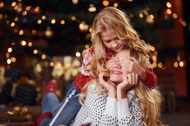 楽しんで、クリスマス休暇を祝っている母と少女。