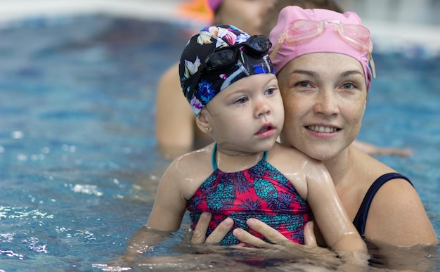 Mother and little girl in the swimming pool