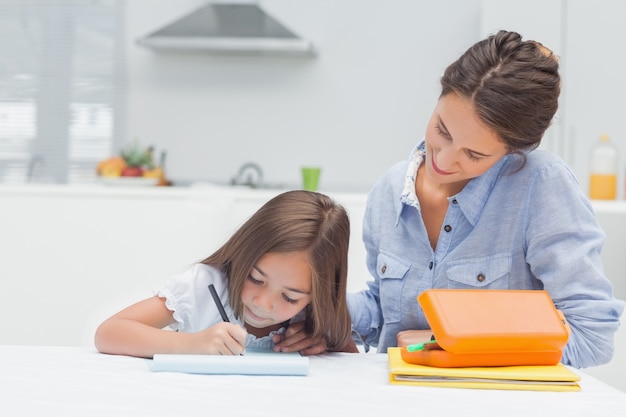 Mother looking at her daughter drawing 