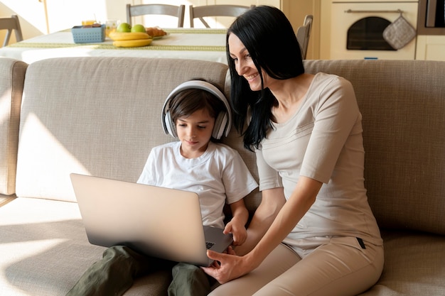 mother looking at what her son is playing on a laptop