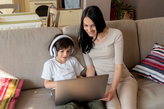 Photo mother looking at what her son is playing on a laptop