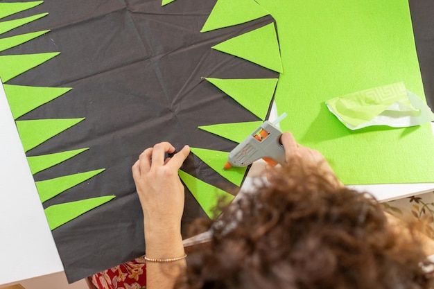 Mother making crafts with scissors and glue with cardboard