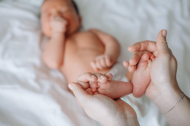 母親の生まれたばかりの赤ちゃんの腕の誕生新しい命