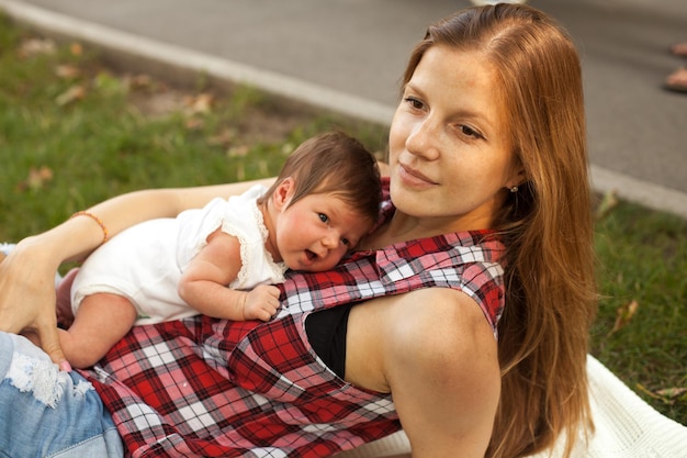 Foto madre e neonata che si godono l'estate nel parco