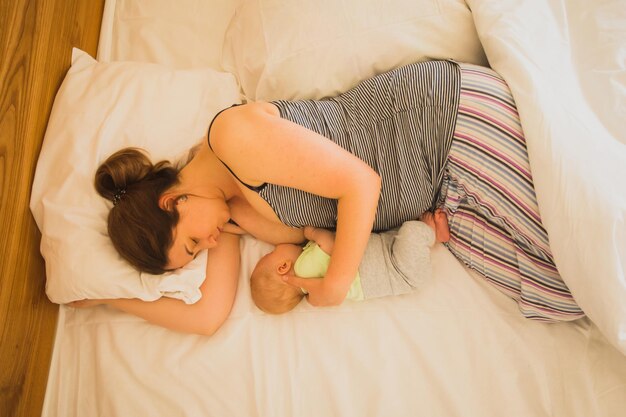 Mother and newborn baby sleep in the bed