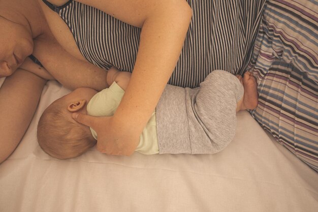 Mother and newborn baby sleep in the bed