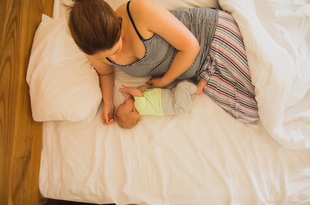 Mother and newborn baby sleep in the bed