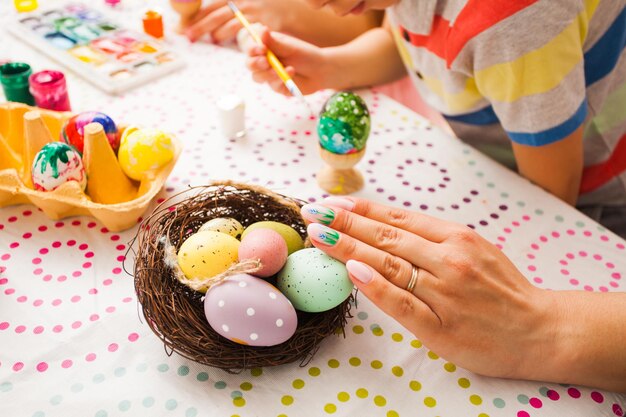 Mother paing ester eggs with kids. close up nails with spring easter manicure, nail design