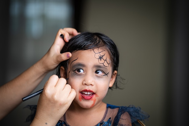 Mother Painting Daughters Face Halloween Party