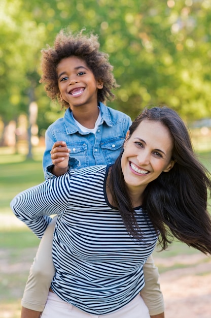 Mother piggybacking son at park