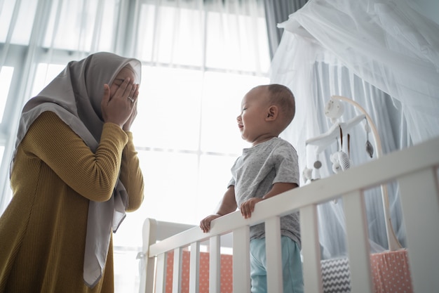 Mother play peek a boo with her son