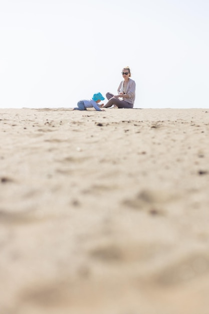 母は砂浜で幼い息子と遊んで夏休みを楽しんでランザロテ島で