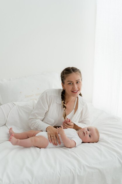 Mother playing with 4 months baby boy on white background kissing holding hugging mile face love