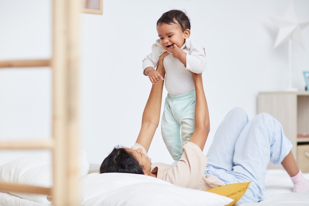 Mother playing with her child in bed