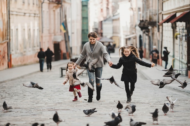 Mother playing with her daughters and birds