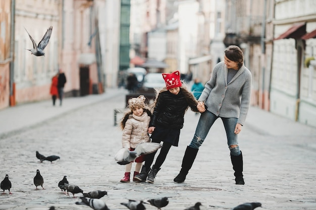 Mother playing with her daughters and birds