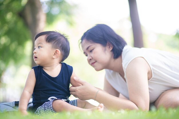 Mother playing with son while sitting in park