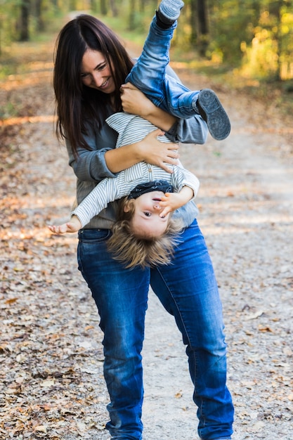 Una madre che gioca con il bambino in una foresta