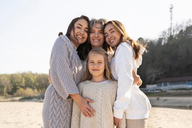 mother posing with her daughters at the beach
