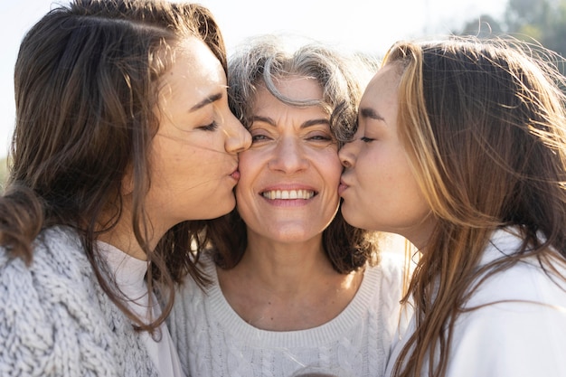 mother posing with her daughters at the beach