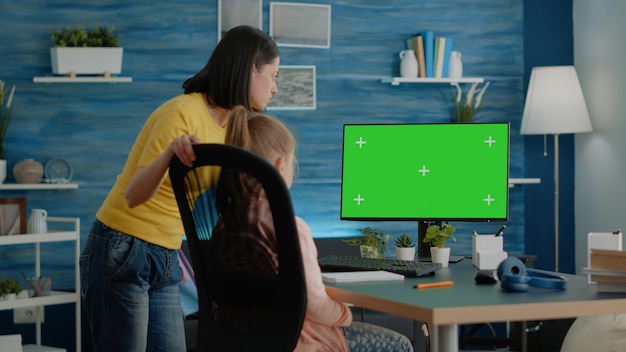 Mother and pupil doing homework with horizontal green screen