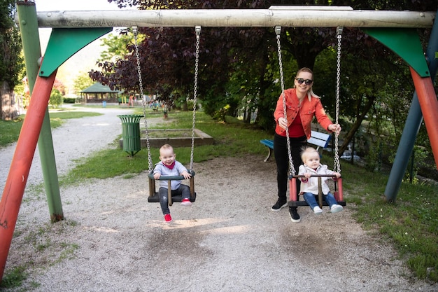 Mother Pushing Her Baby's Having Fun on Swing