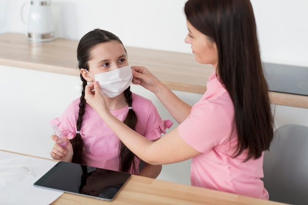 Mother putting mask on daughter