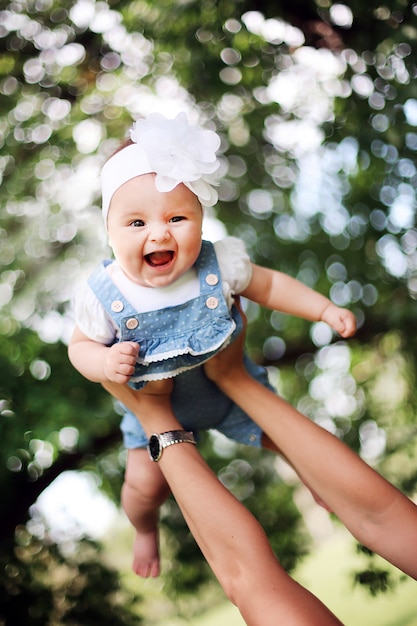 Photo mother raises up her smiling child.