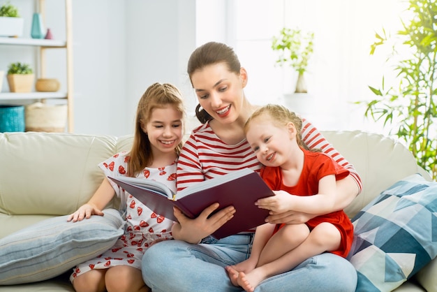 Mother reading a book to daughters