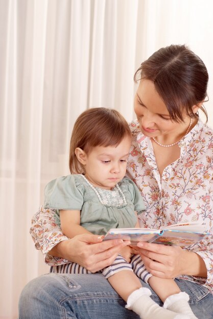 彼女の小さな女の子と本を読んでいる母