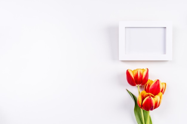 Concetto di design per la festa della mamma mazzo di fiori di tulipano bellissimo bouquet rosso giallo isolato su sfondo bianco luminoso vista dall'alto del tavolo spazio per la copia piatta