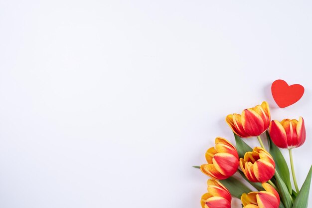 Foto giorno della madre giorno di san valentino sfondo bouquet di fiori di tulipani bellissimo bouquet rosso giallo isolato su tavolo bianco vista piatta posa mock up concetto di design