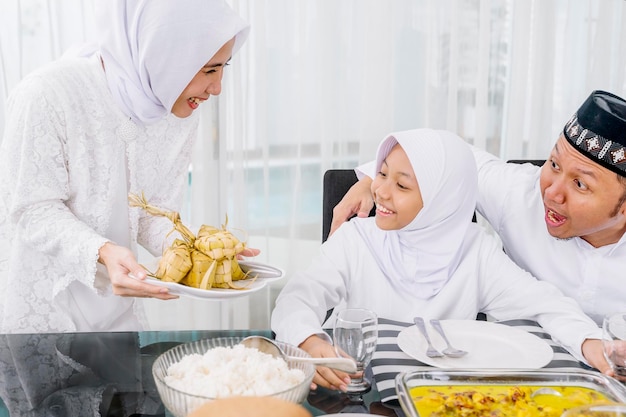 Mother serving ketupat for her family at Eid