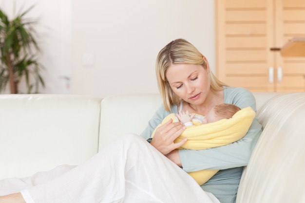 Mother sitting on the couch with her baby in her arms