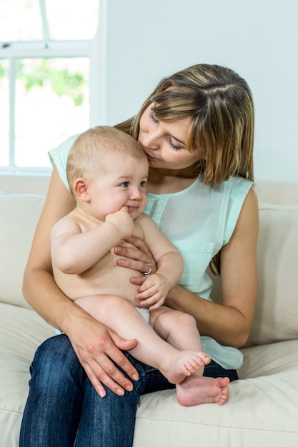 Mother sitting with cute son on sofa