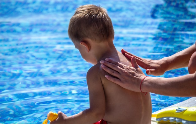 Mother smears the child with sunscreen