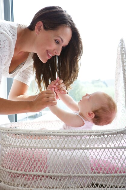 Mother smiling with infant child in bed