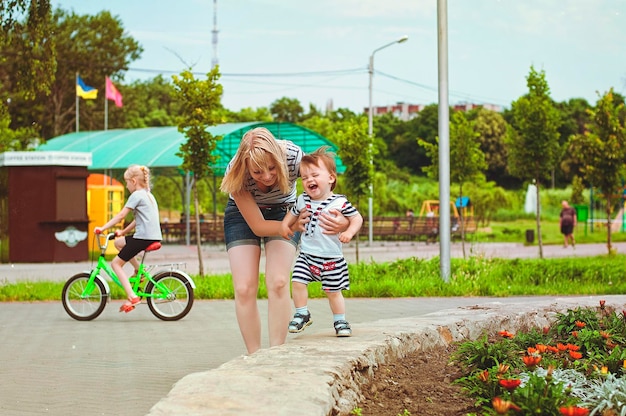 Mother and son are playing in the park and laughing on a summer walk on a sunny day.  Family holiday