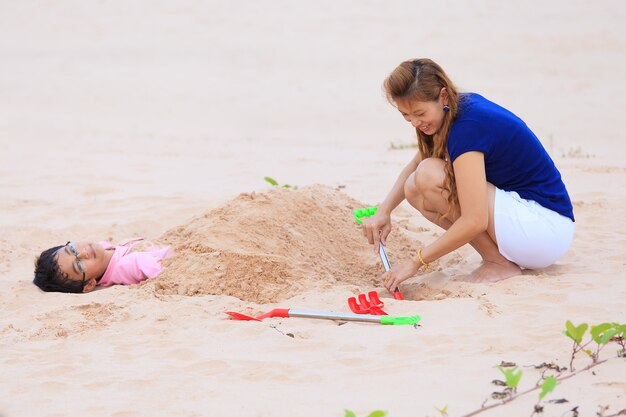 Photo mother and son are playing on tropical beach