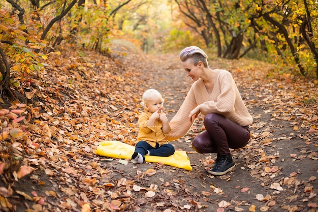 Mother and son in autumn background with golden trees