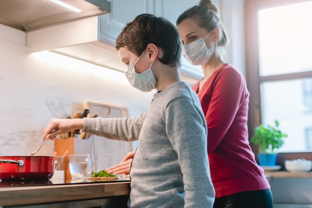 Mother and son cooking at home during the crisis time