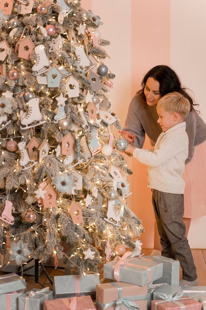 Madre e figlio che decorano il concetto dell'albero di natale