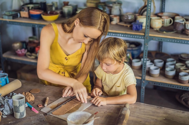 Mother and son doing ceramic pot in pottery workshop