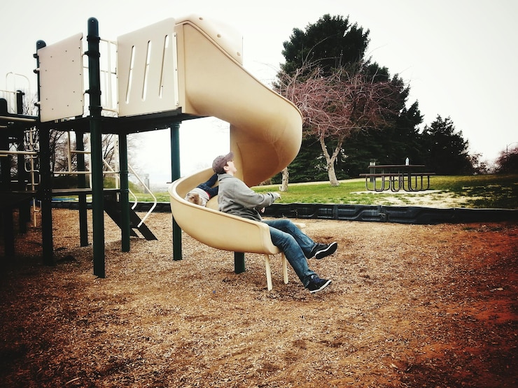 Photo mother and son enjoying slide at playground