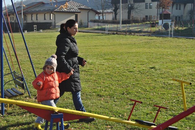 mother and son holding hands while standing at playground