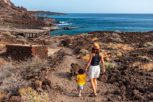 Mother and son on holiday on a path along the beach at Tacoron on El Hierro Canary Islands