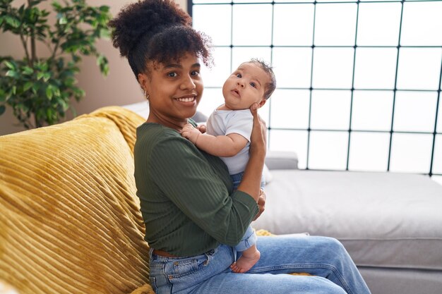 Mother and son hugging each other sitting on sofa at home